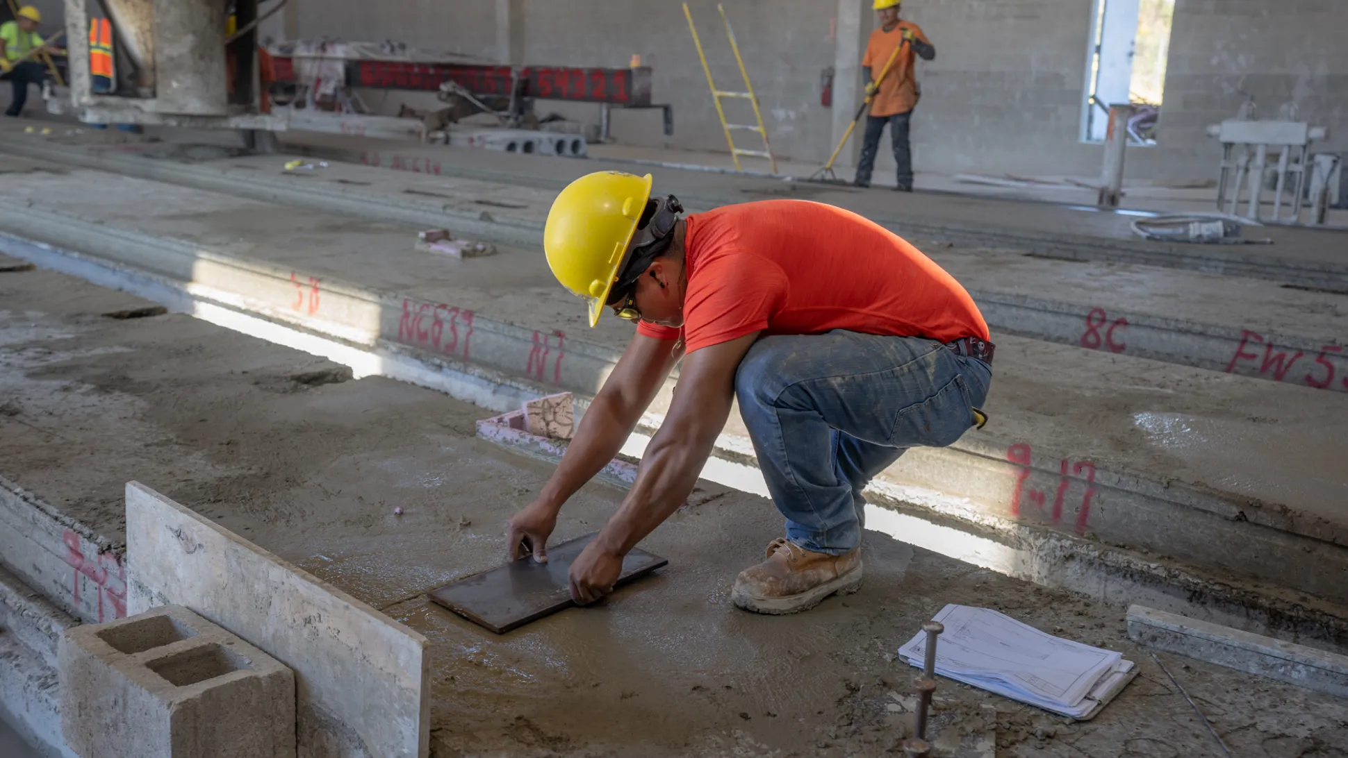 Construction worker in the production process of a hollow core precast concrete slab.